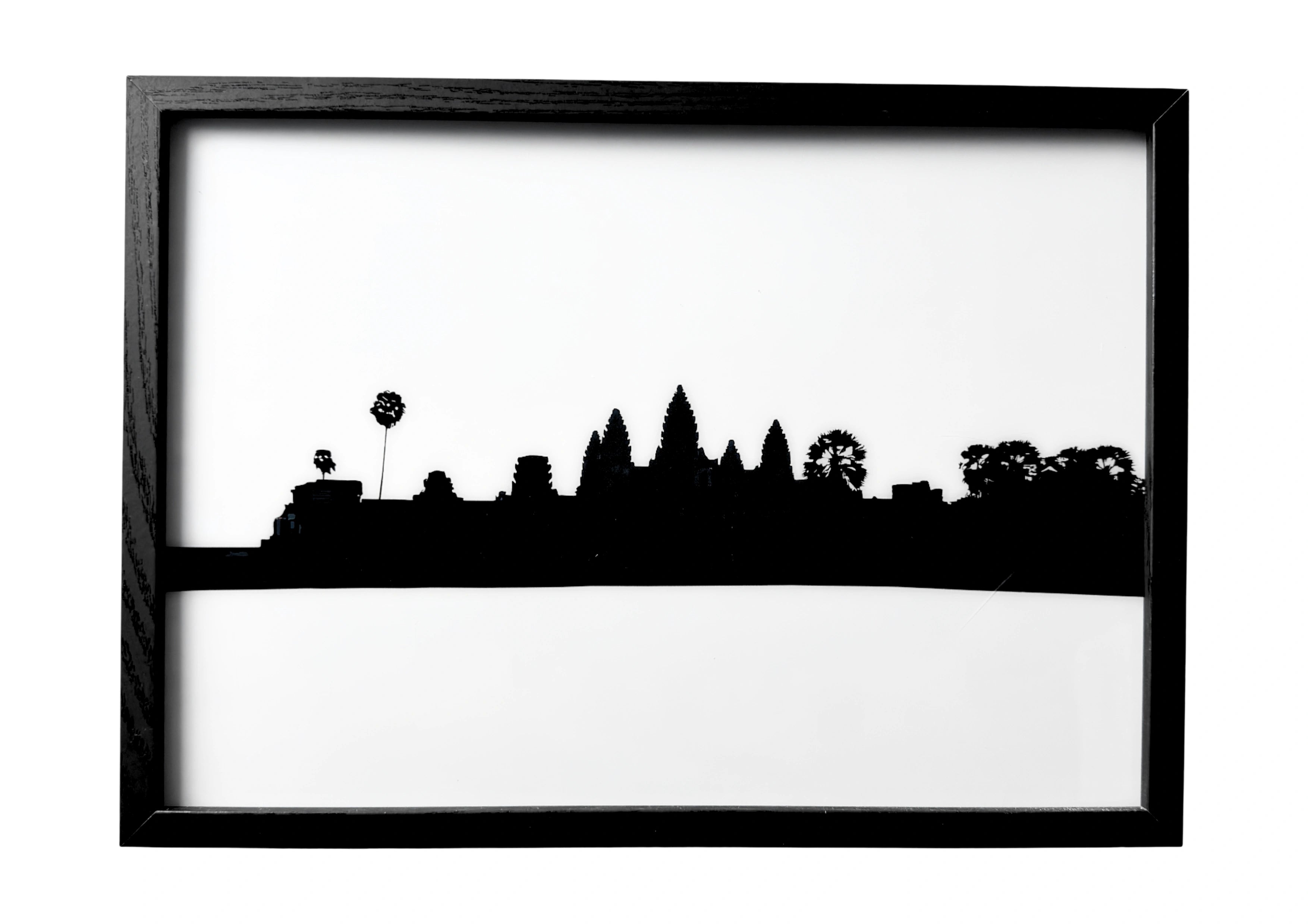 Angkor Wat wall art in calm silhouette — temple spires resting above still water, a tranquil symbol of dawn’s anticipation.