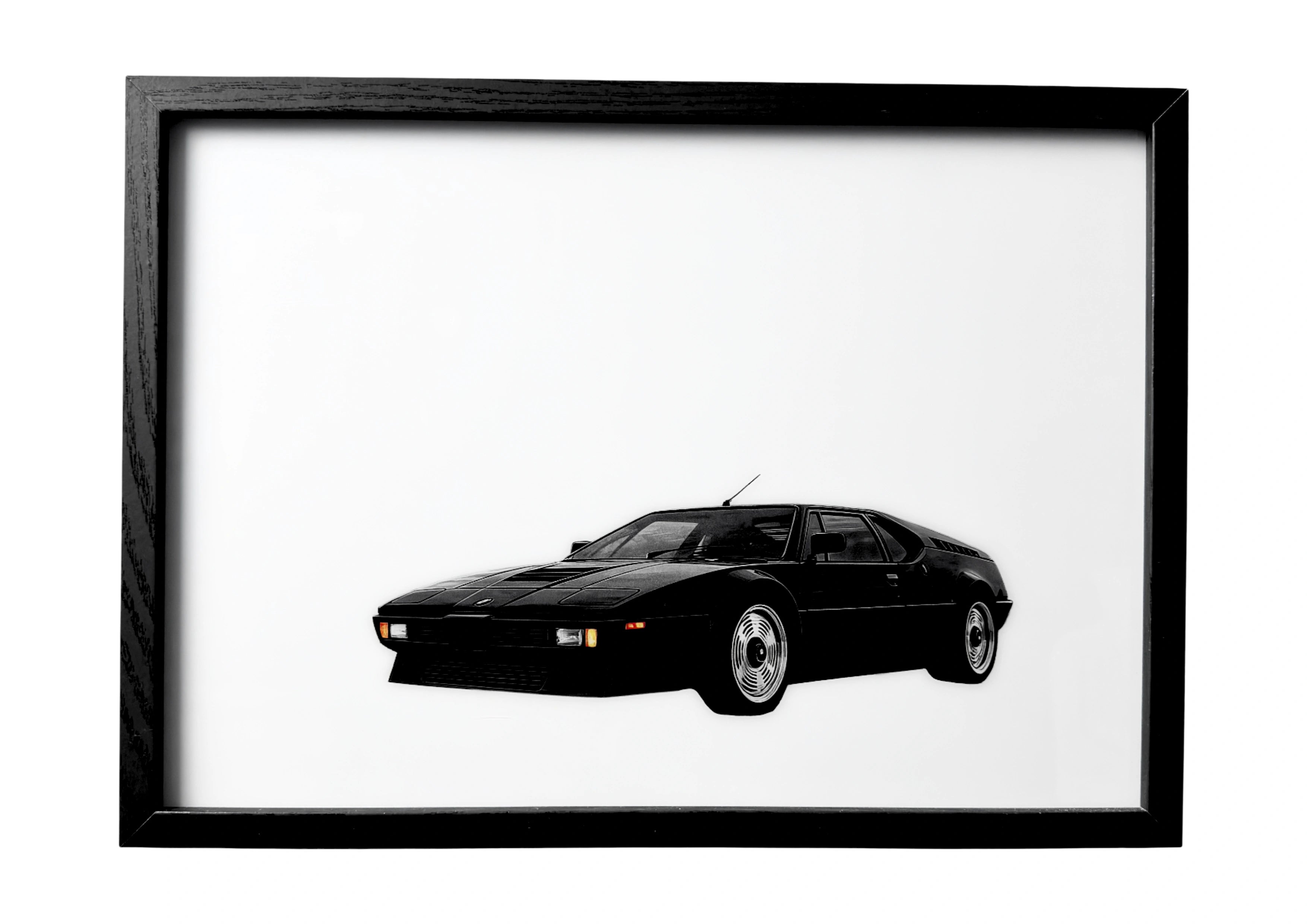 BMW M1 wall art front three-quarter view in black with amber lights. A framed celebration of German automotive precision.